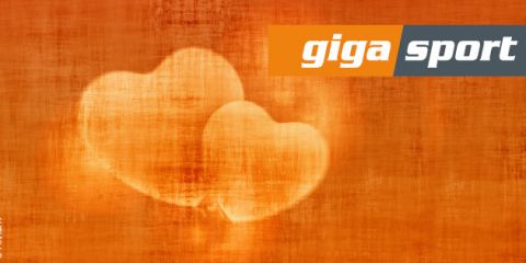 Ein abstraktes Bild mit zwei überlappenden Herzen in Hellorange auf strukturiertem orangefarbenem Hintergrund. In der oberen rechten Ecke befindet sich ein Logo mit dem weißen Text „Giga Sport“ in orangefarbenen und grauen Rechtecken.