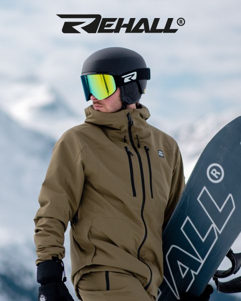 Uno snowboarder con giacca marrone chiaro e casco con occhiali riflettenti tiene in mano uno snowboard, sullo sfondo montagne innevate e sopra il logo "REHALL".