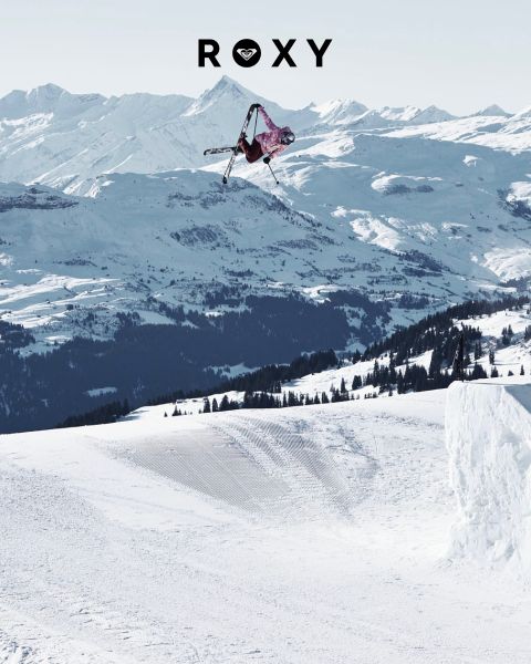 Tre donne nuotano sott'acqua in costume da bagno in acque limpide e blu. Una indossa una maglia a maniche lunghe, le altre dei bikini. L'immagine è sovrapposta al logo bianco "Roxy".