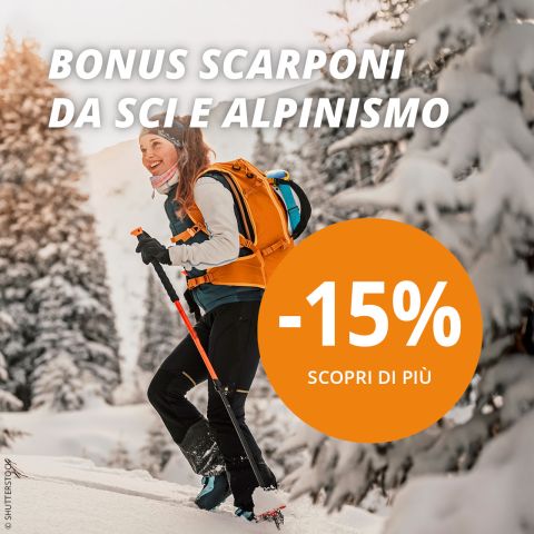 Uno sciatore con uno zaino arancione si muove in salita in un paesaggio boschivo innevato. Un testo in lingua italiana pubblicizza uno sconto del 15% su scarponi da sci e da montagna.