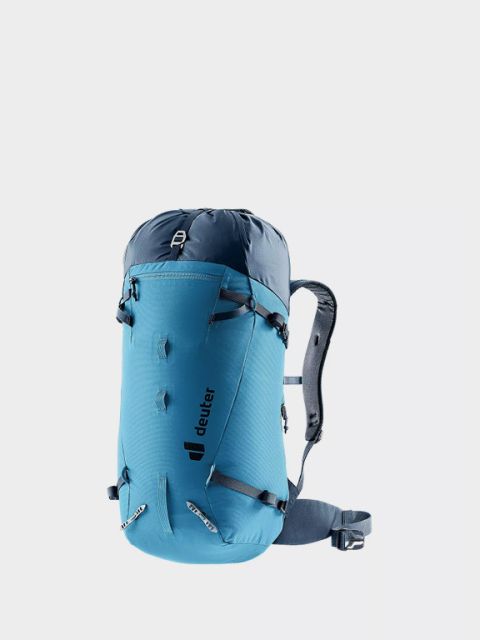 Su uno sfondo grigio chiaro è raffigurato uno zaino Ortovox verde con tasche laterali in rete e supporti per piccozza. In alto a sinistra, in grassetto e in lettere bianche, si legge "Zaini alpini".