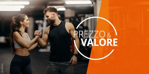 Un uomo e una donna in abbigliamento sportivo sorridono e si stringono la mano in una palestra, con il testo "Prezzo & Valore" su uno sfondo arancione.