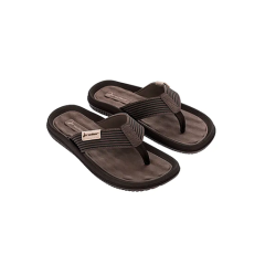 Un paio di sandali infradito marroni e neri con cinturini testurizzati su uno sfondo circolare bianco.