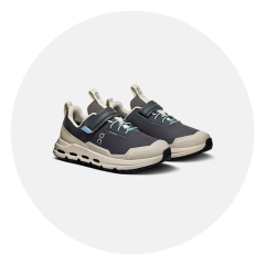 Un paio di scarpe sportive nere e beige con accenti blu, chiusure a strappo e suole spesse, raffigurate su uno sfondo bianco.